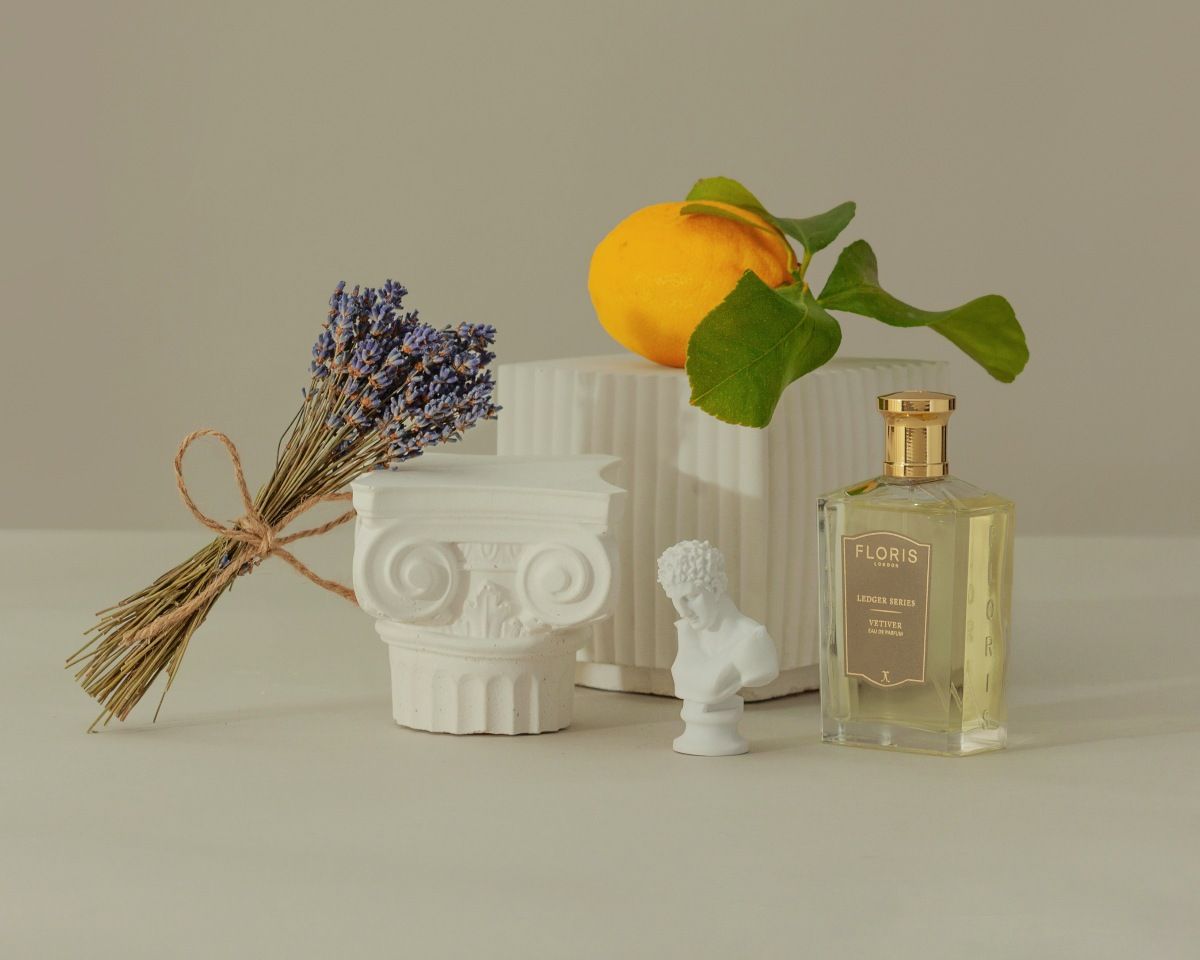 Vetiver from Floris shown on beige background with flowers and fruits